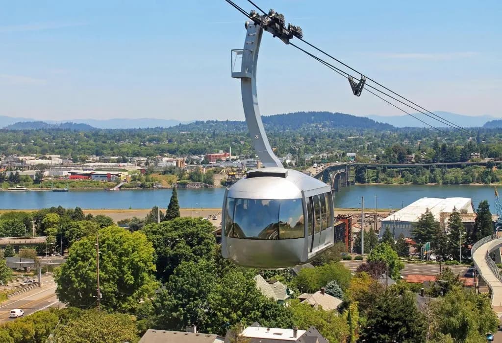 Portland Aerial Tram gliding above the Willamette River with the city and mountains in the distance